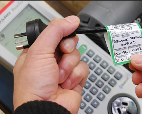 Person holding a power cord tag.