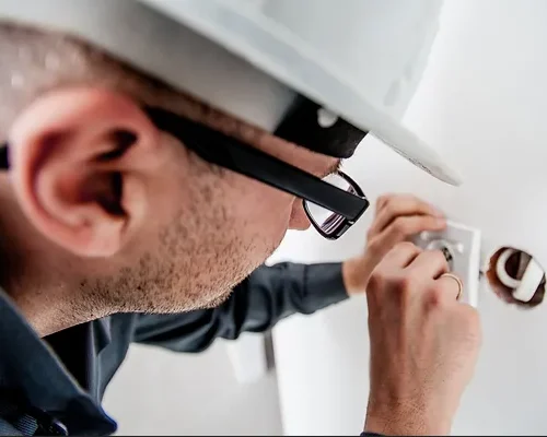 Electrician inspecting a power outlet.