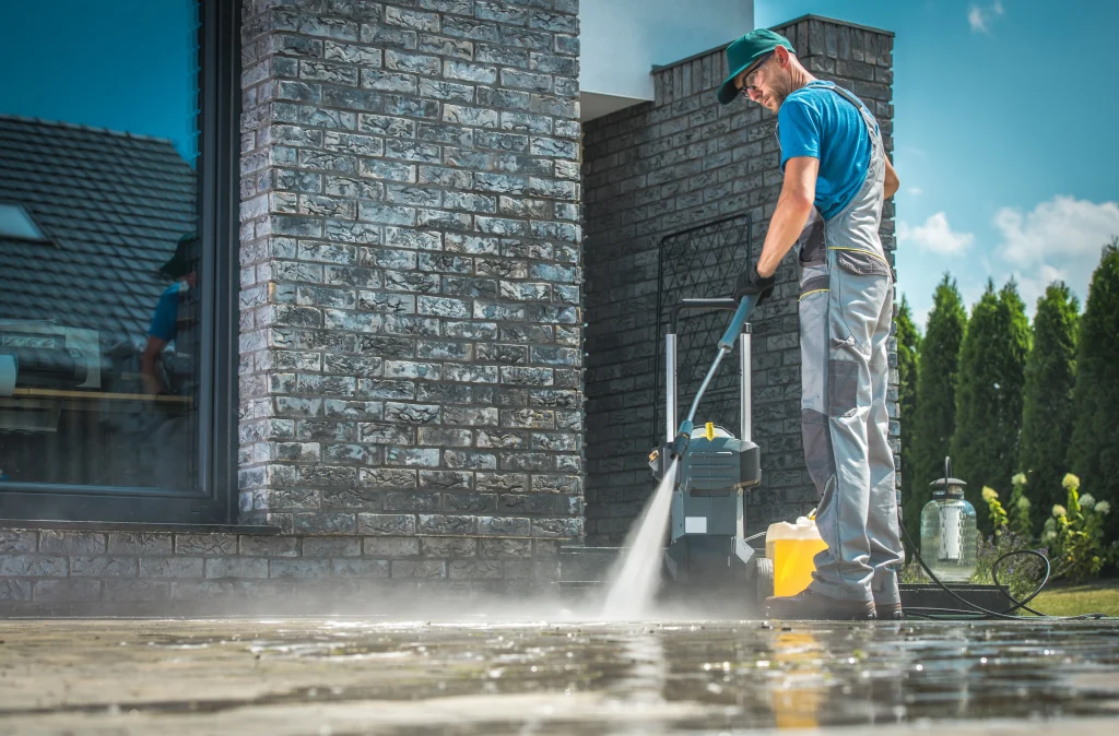 Man in his backyard figuring out how to use a pressure washer.