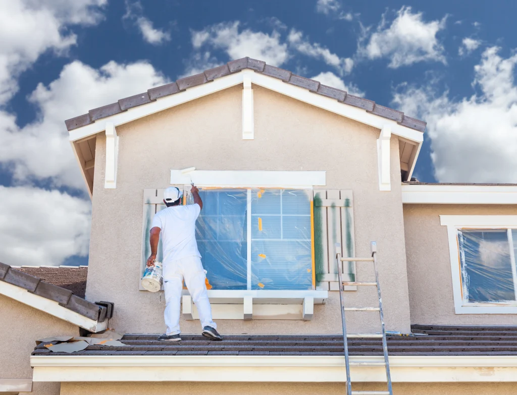 Man painting house after finding out how long to paint a house.