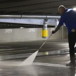 Worker performing high-pressure Car park cleaning in an indoor car park in Melbourne