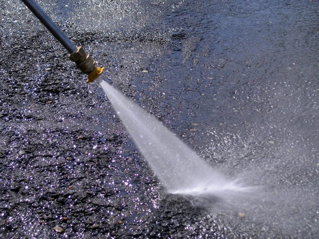 Close-up of high-pressure water jet cleaning a car park surface in Melbourne