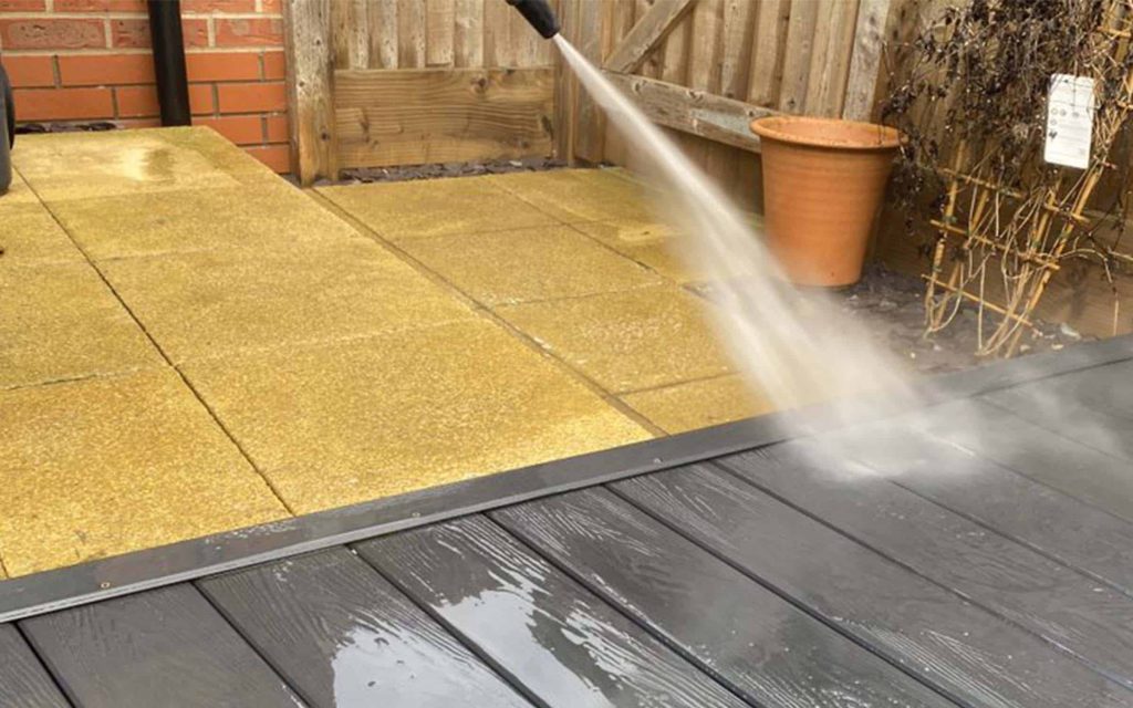 High-pressure cleaning of a composite deck and patio in Melbourne.