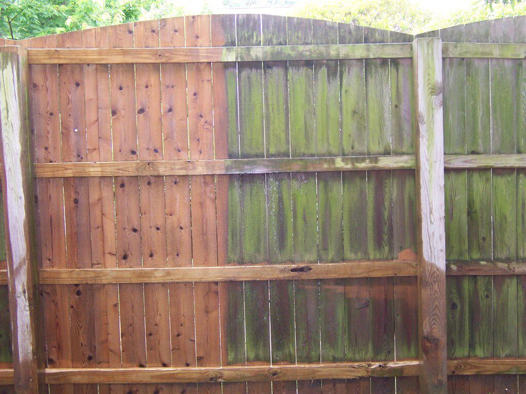 Wooden fence with a clear before-and-after view of professional fence cleaning services in Melbourne removing green algae and grime.