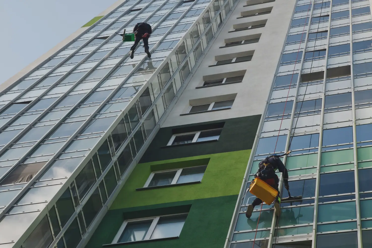 Worker using a high-powered washer to clean a stained driveway Full Building Exterior Cleaned