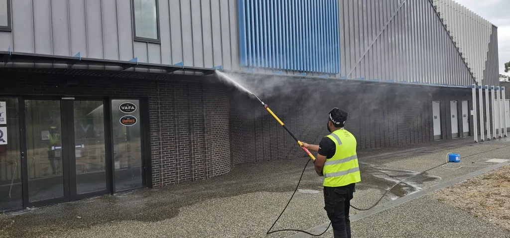 Painter applying fresh coat of paint to exterior wall
