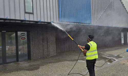 Painter applying fresh coat of paint to exterior wall